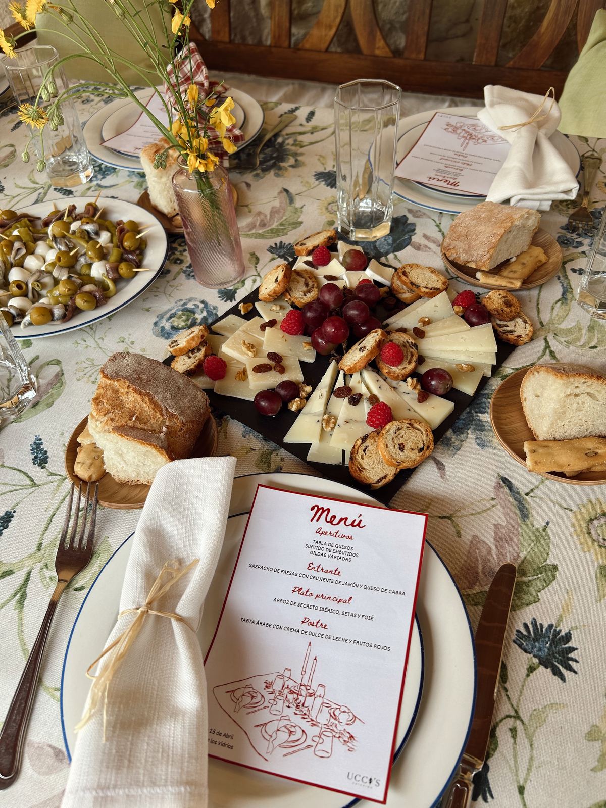 Mesa con carta de menú, quesos y frutos rojos