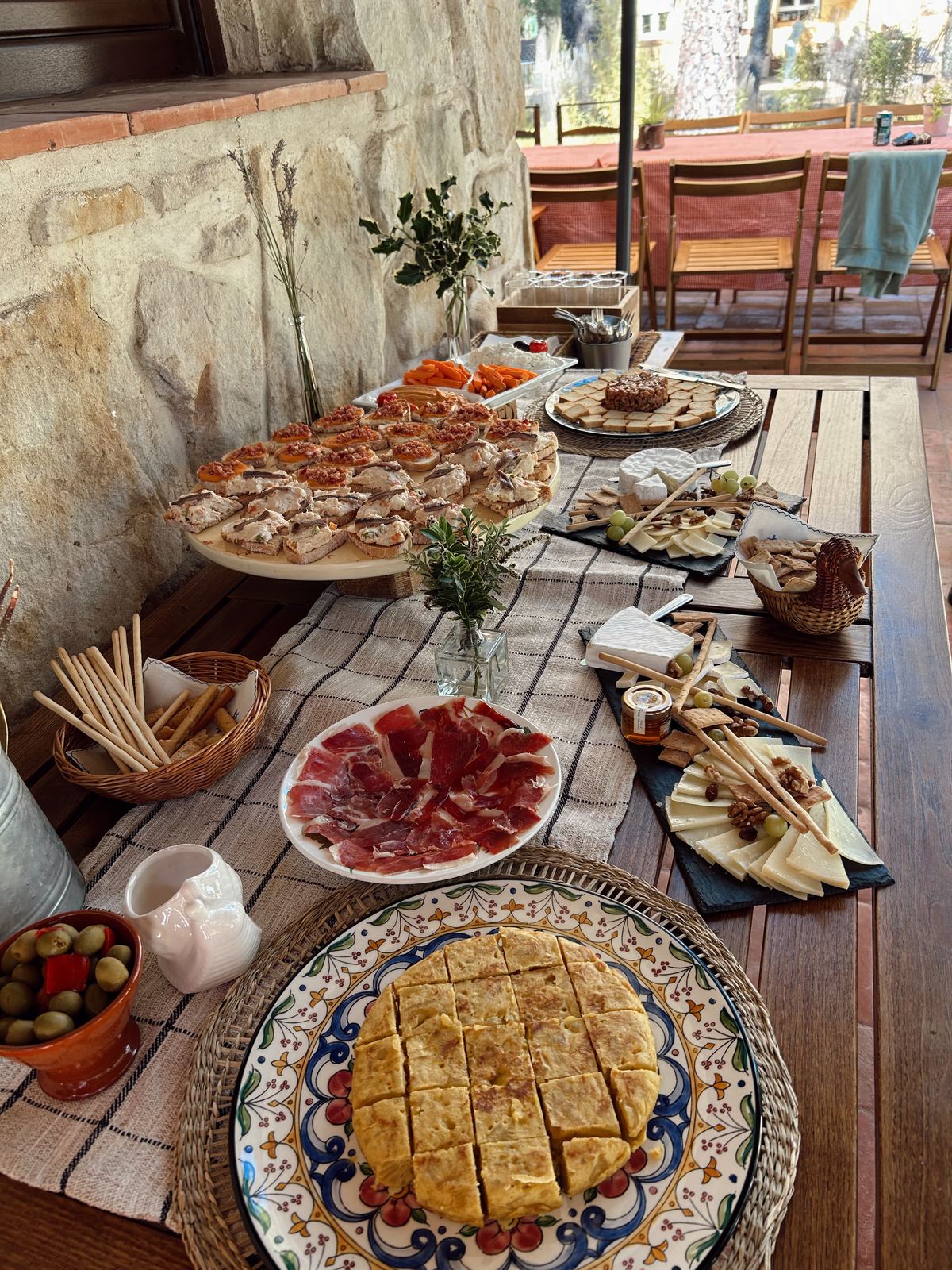 Mesa de cóctel con jamón, tortilla y tabla de quesos
