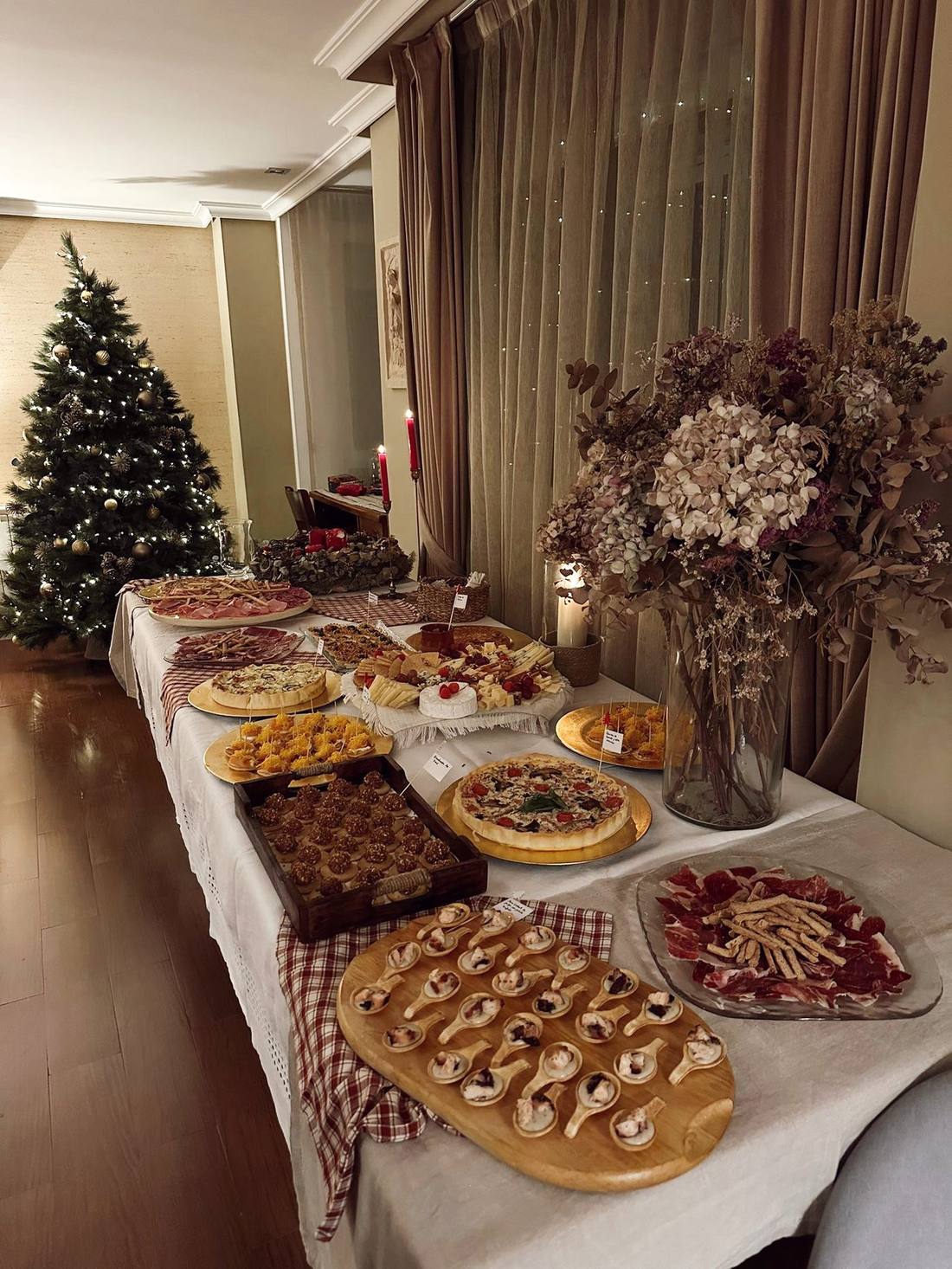 Mesa de cóctel navideña con tabla de quesos, embutidos y tacos